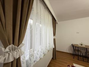 a window with white curtains in a room at Casa Bunicii in Târgu Neamț
