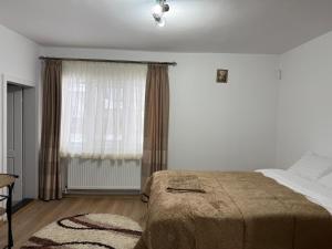 a white bedroom with a bed and a window at Casa Bunicii in Târgu Neamț