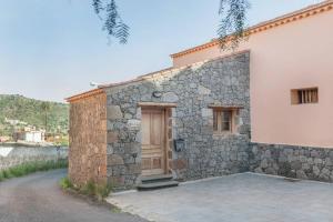 a stone building with a wooden door on it at La 68 in Santa Brígida