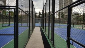 a tennis court through a fence with a tennis court at 2br Luxury apartment in Jakarta
