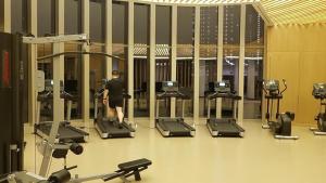 a man walking in a gym with cardio machines at 2br Luxury apartment in Jakarta