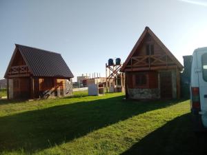 two small wooden buildings sitting on a grass field at Entre aromos y lavandas in San Clemente del Tuyú +9 photos