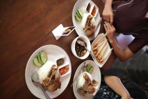 a wooden table with plates of food on it at The Secreet Garden Hotel in Denpasar