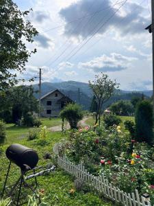 a garden with flowers and a white fence at Sosnova hilka in Mykulychyn +77 photos