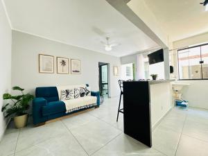a living room with a blue couch and a table at Ap Aconchego 210 B in Ubatuba