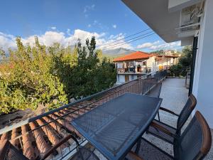a table and chairs on the balcony of a house at Anemeli 2-bedroom apartment, Stoupa in Stoupa