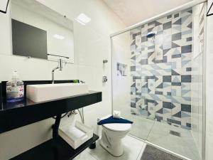 a bathroom with a toilet and a sink and a shower at Ap Aconchego 210 B in Ubatuba +20 photos