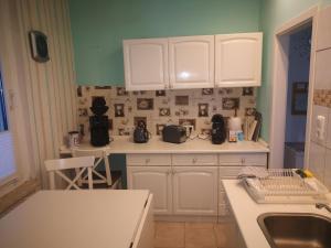 a kitchen with white cabinets and a white counter top at Ferienwohnung Dickes in Brandenburg an der Havel