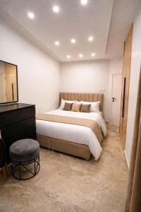 a bedroom with a large bed and a stool at Casa Amor in Neum
