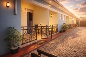 a balcony with a table and chairs on a building at Kanti Guest House, Arua in Arua