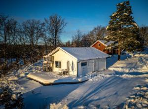 a small white shed in the snow with a tree at Wild Lodge in Nol