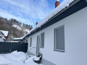 a white house with snow on the roof at Ellas Ferienhaus in Elbingerode