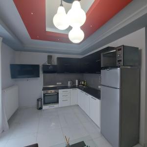 a kitchen with white appliances and a red ceiling at Andromachi Apartments in Jembke