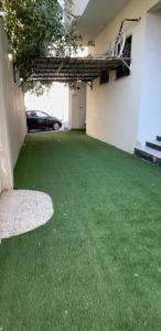 a garage with a green yard with a car parked at شقة الخالدية 1 in Medina
