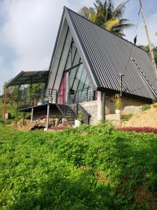 a house with a black roof on top of a hill at Ella Grand Cabin in Ella