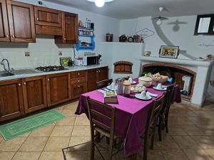 a kitchen with a table with a purple table cloth at Locanda B&B Dandana in Orgosolo +44 photos