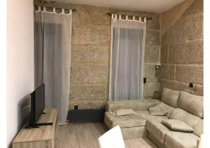 a living room with a couch and a television at Piso con vistas a 30m playa ALOJAMIENTOS VACAY in Bueu