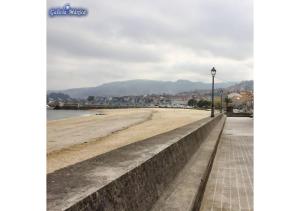 a view of a beach with a street light at Piso con vistas a 30m playa ALOJAMIENTOS VACAY in Bueu +8 photos
