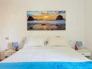 a bedroom with a bed with a painting on the wall at Casa Mia - Baia Verde in Baia Verde