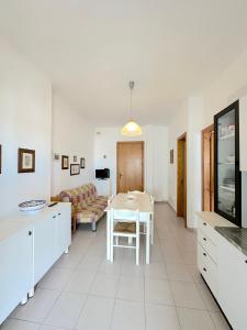a kitchen and living room with a table and a couch at Casa Mia - Baia Verde in Baia Verde