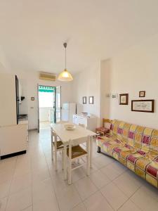 a living room with a table and a couch at Casa Mia - Baia Verde in Baia Verde +8 photos