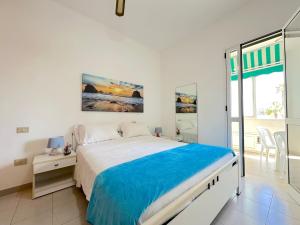 a white bedroom with a large bed and a window at Casa Mia - Baia Verde in Baia Verde