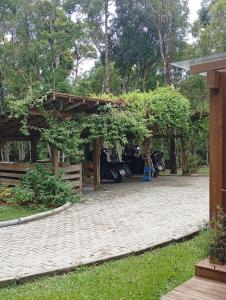a pavilion with a table and a chair in a yard at Casa Bosque Encantador in Rancho Queimado +2 photos