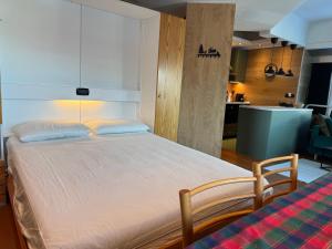 a large bed in a room with a kitchen at Panorama Marilleva 1400 - Val di Sole in Marilleva