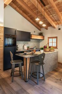 a kitchen with a table and two chairs and a counter at Baita Valon La Piciola in Stenico