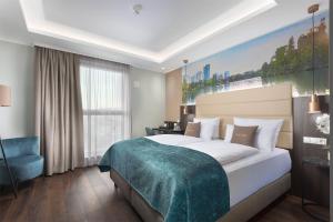 a bedroom with a large bed and a large window at Mercure Frankfurt Offenbach in Offenbach