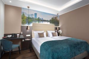 a bedroom with a large bed and a desk and chair at Mercure Frankfurt Offenbach in Offenbach