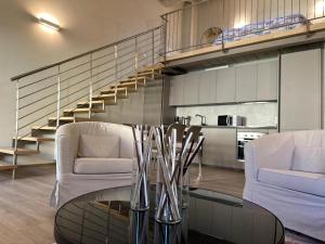 a living room with two chairs and a glass table at Casa Lore in Pontedera