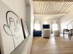 a living room with a painting of a face on the wall at Casa Lore in Pontedera +5 photos