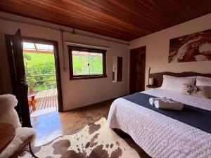 a bedroom with a bed and a sliding glass door at Refúgio Horse in Santo Antônio do Pinhal