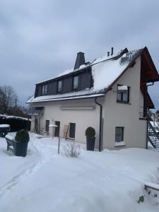 a white house with snow on the roof at Ferienwohnung Schreiter in Arnsfeld