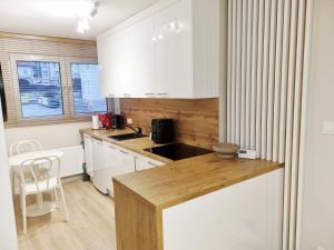 a kitchen with white cabinets and a wooden counter top at Apartament Sobótka in Sobótka