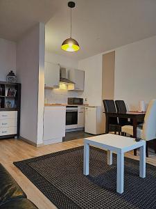 a living room with a table and a kitchen at Cottbuser City Apartment in Cottbus
