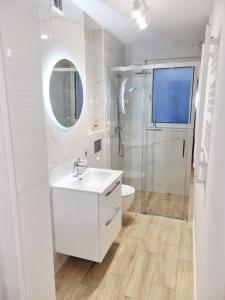 a white bathroom with a sink and a shower at Apartament Sobótka in Sobótka +18 photos