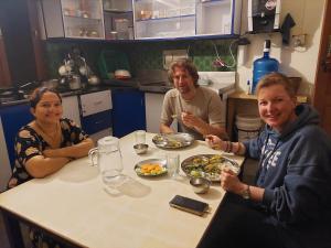 a group of people sitting around a table eating food at Blue Planet Lodge & Restaurant in Pokhara +29 photos