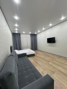 a room with a bed and a flat screen tv at ЖК Central Park in Aktobe