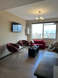 a living room with a couch and chairs and a tv at Paseo Recoleta in Cochabamba