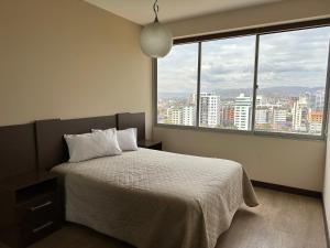 a bedroom with a bed with a view of a city at Paseo Recoleta in Cochabamba