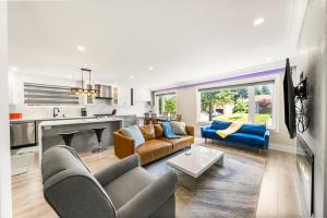 a living room with couches and a kitchen at 5 Bedroom Luxury Spa Escape with Pool & Jacuzzi in Toronto