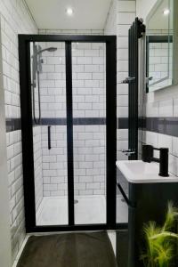 a bathroom with a shower with a glass door at The Mews & Studio in Ivybridge