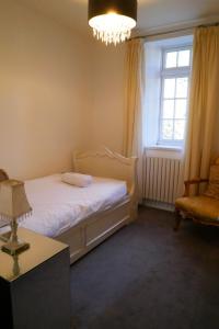 a bedroom with a bed and a window and a chair at The Mews & Studio in Ivybridge