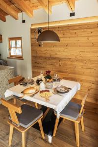 a dining room with a white table and chairs at Baita Valon La Piciola in Stenico