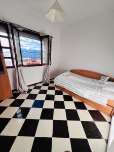 a bedroom with a bed and a checkered floor at Blue Pearl city in Chefchaouen
