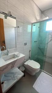 a bathroom with a sink and a toilet and a glass shower at Pousada Cabana in Avaré +7 photos