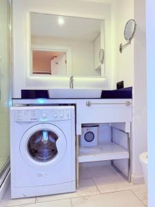 a washing machine in a bathroom with a mirror at ASKO aprtament beach batumi in Batumi +2 photos