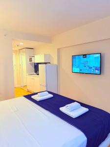 a bedroom with a large bed with a tv on the wall at ASKO aprtament beach batumi in Batumi